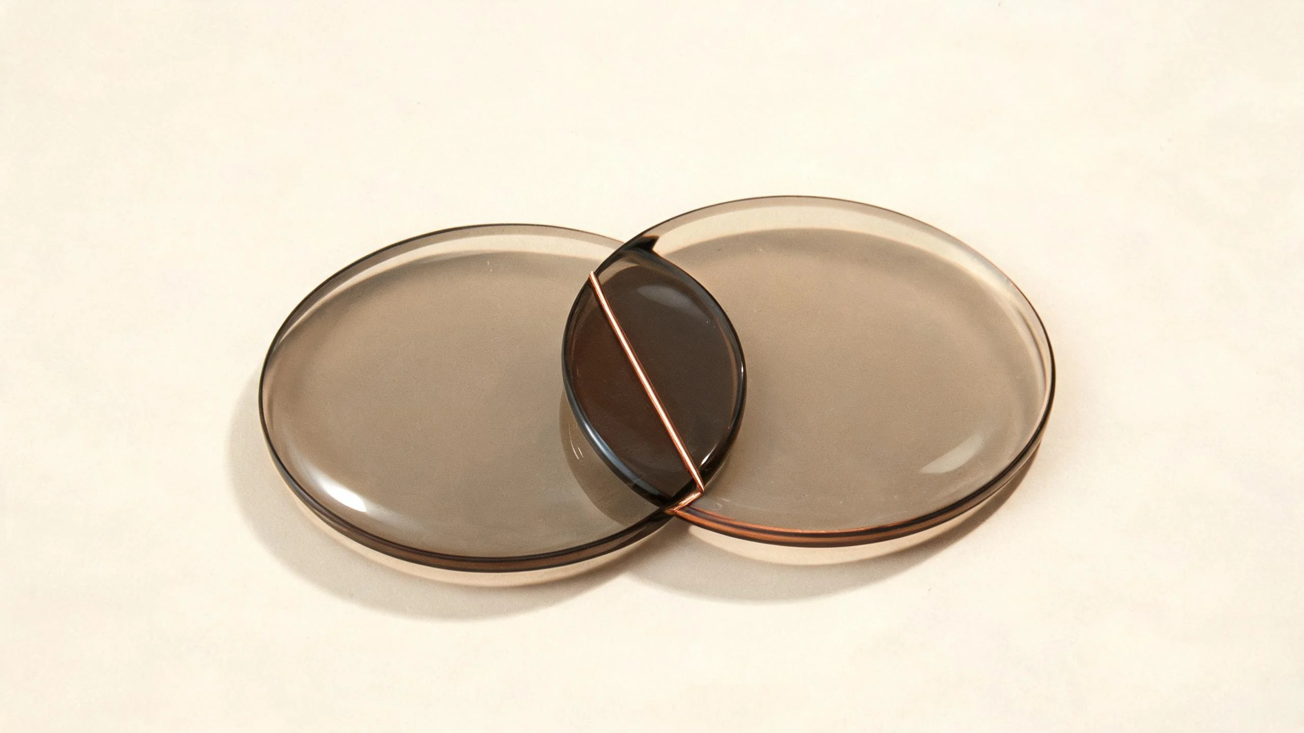 Two overlapping smoked-glass charts joined by a fine copper composite line